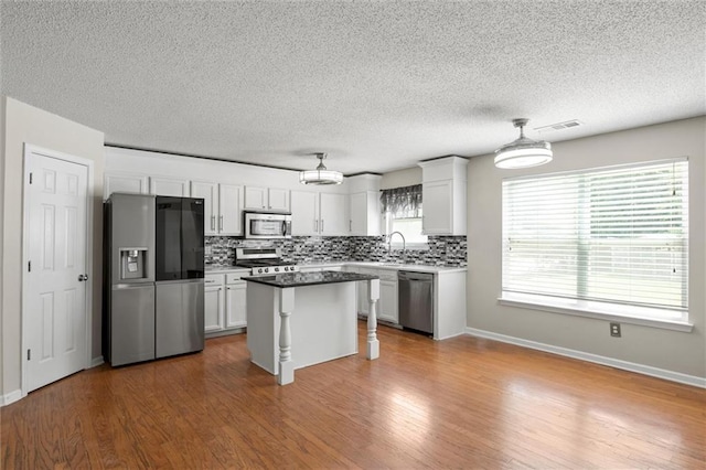 kitchen featuring appliances with stainless steel finishes, white cabinets, and plenty of natural light