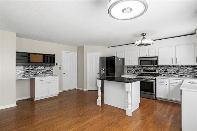 kitchen featuring dark wood-type flooring, stainless steel appliances, a breakfast bar, a center island, and white cabinetry