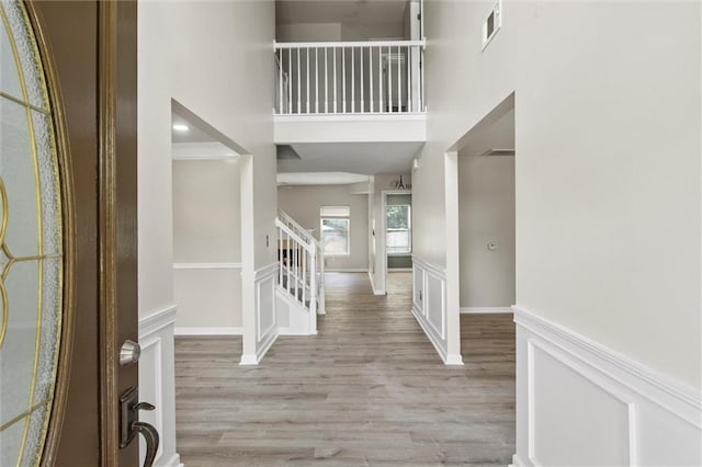 entrance foyer featuring light hardwood / wood-style floors and a towering ceiling