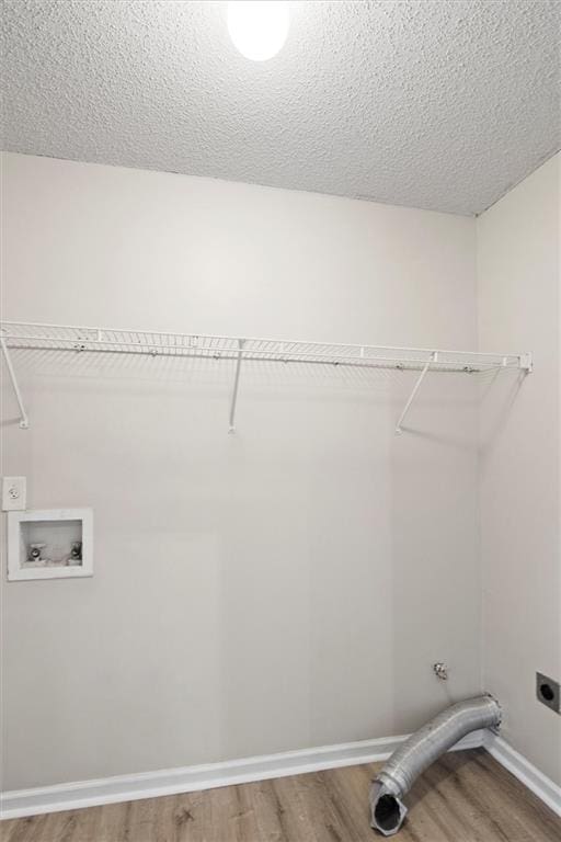 laundry room featuring hookup for an electric dryer, hardwood / wood-style floors, hookup for a washing machine, and a textured ceiling