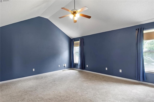 carpeted spare room with vaulted ceiling and ceiling fan