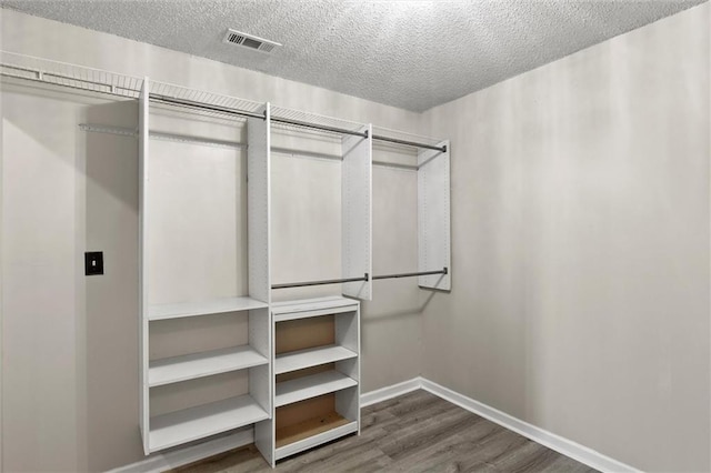 spacious closet with dark hardwood / wood-style flooring