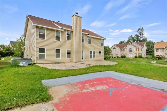 rear view of property with a patio and a lawn