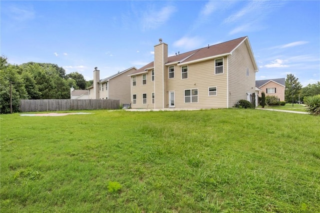 rear view of property featuring a lawn