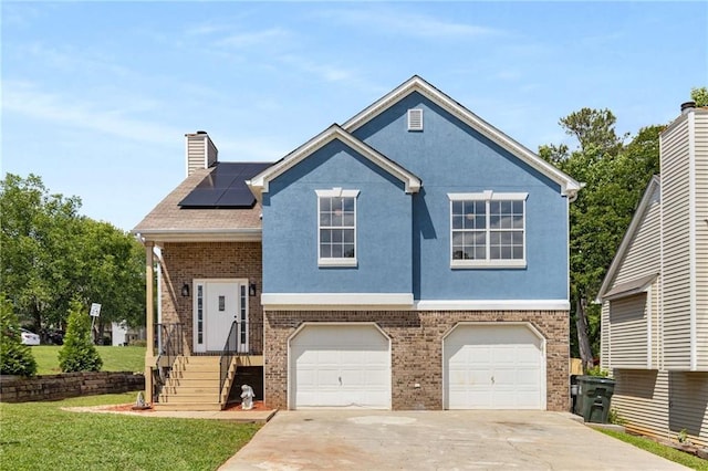 view of front facade featuring driveway, roof mounted solar panels, a garage, and brick siding