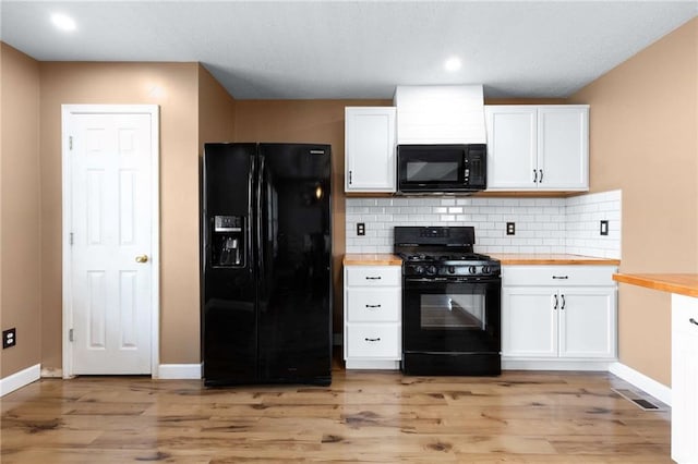 kitchen featuring black appliances, white cabinets, wood counters, baseboards, and backsplash