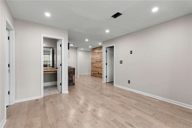 unfurnished living room with light wood-type flooring, recessed lighting, and baseboards