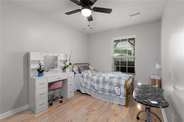 bedroom featuring light wood-style floors, a desk, baseboards, and ceiling fan