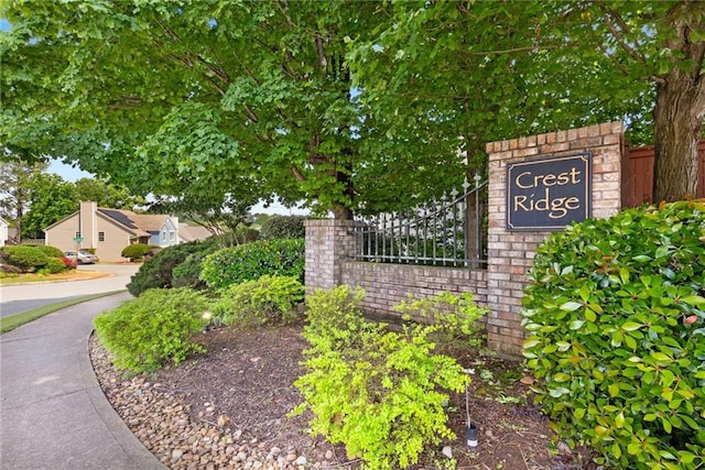 community / neighborhood sign featuring fence