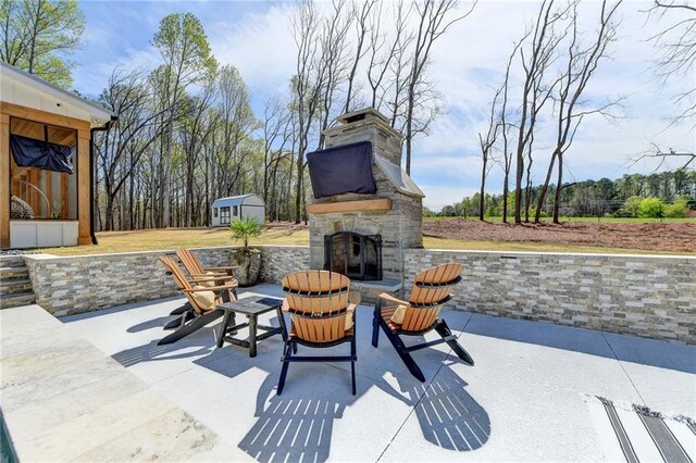 132 Swift Creek Way, Jefferson, GA 30549 - view of patio / terrace featuring an outdoor stone fireplace and an outbuilding