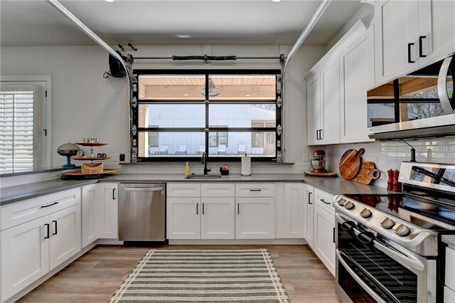 132 Swift Creek Way, Jefferson, GA 30549 - kitchen with white cabinets, stainless steel appliances, light hardwood / wood-style flooring, and sink