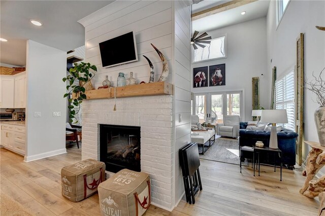 132 Swift Creek Way, Jefferson, GA 30549 - living room with light hardwood / wood-style flooring, a high ceiling, and a brick fireplace