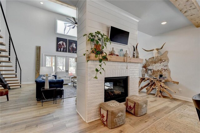 132 Swift Creek Way, Jefferson, GA 30549 - living room featuring a fireplace, a high ceiling, and light hardwood / wood-style flooring