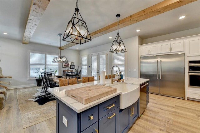 132 Swift Creek Way, Jefferson, GA 30549 - kitchen with appliances with stainless steel finishes, sink, decorative light fixtures, white cabinetry, and an island with sink
