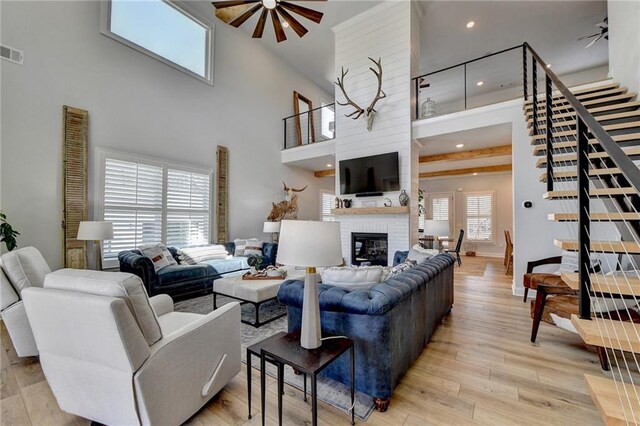 132 Swift Creek Way, Jefferson, GA 30549 - living room featuring ceiling fan, light wood-type flooring, a towering ceiling, and a brick fireplace