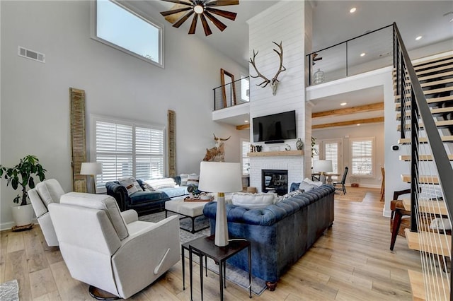 132 Swift Creek Way, Jefferson, GA 30549 - living room featuring a fireplace, ceiling fan, light hardwood / wood-style flooring, and a towering ceiling