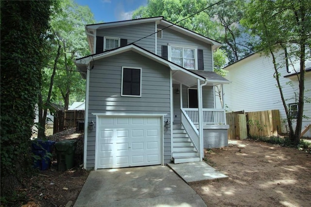 traditional home with a garage, covered porch, and fence