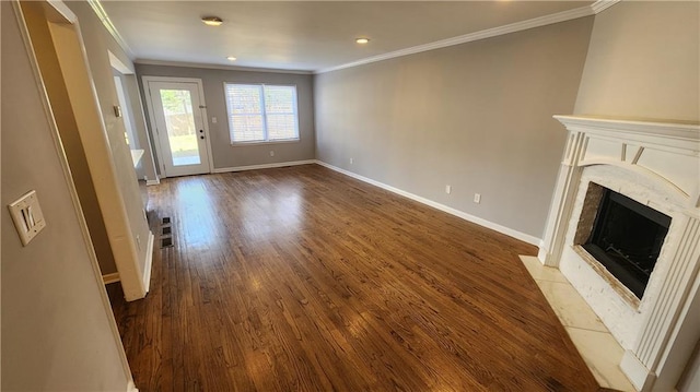 unfurnished living room with crown molding, a fireplace, baseboards, and wood finished floors