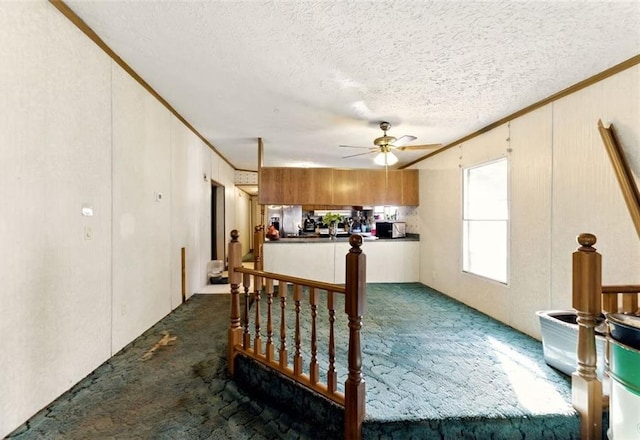 interior space featuring dark colored carpet, crown molding, a textured ceiling, and stainless steel fridge with ice dispenser