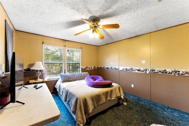 carpeted bedroom with a textured ceiling and a ceiling fan