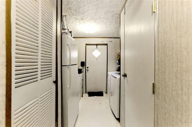 washroom featuring laundry area, washer and clothes dryer, and a textured ceiling