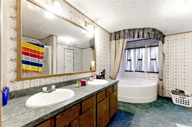 bathroom with a sink, a textured ceiling, and wallpapered walls