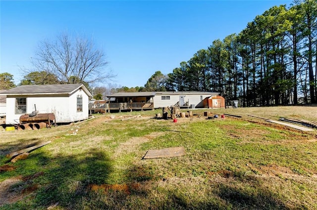 back of house featuring a storage shed, a yard, and an outbuilding