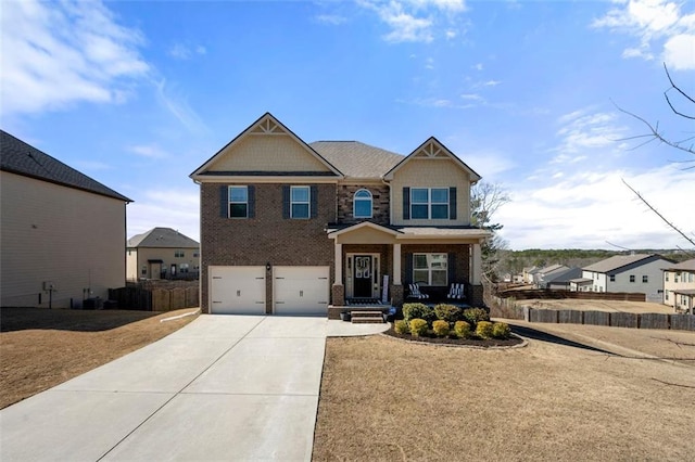 craftsman inspired home with a garage, driveway, covered porch, fence, and brick siding