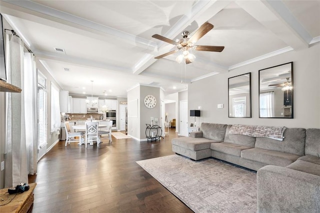 living area with ceiling fan with notable chandelier, dark wood-style flooring, baseboards, beam ceiling, and crown molding