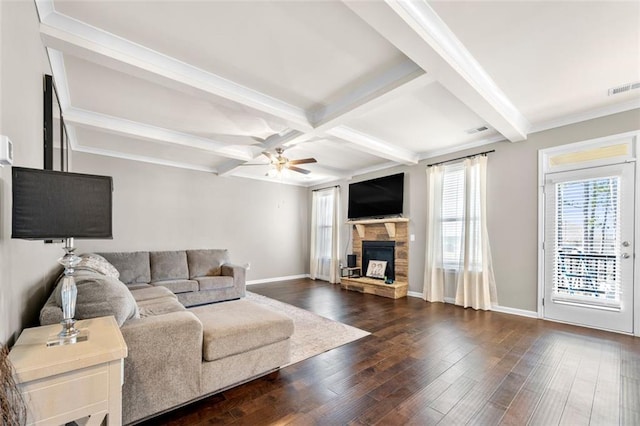 living area featuring dark wood-style floors, beam ceiling, visible vents, and a stone fireplace