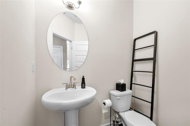 bathroom with baseboards, a sink, and toilet