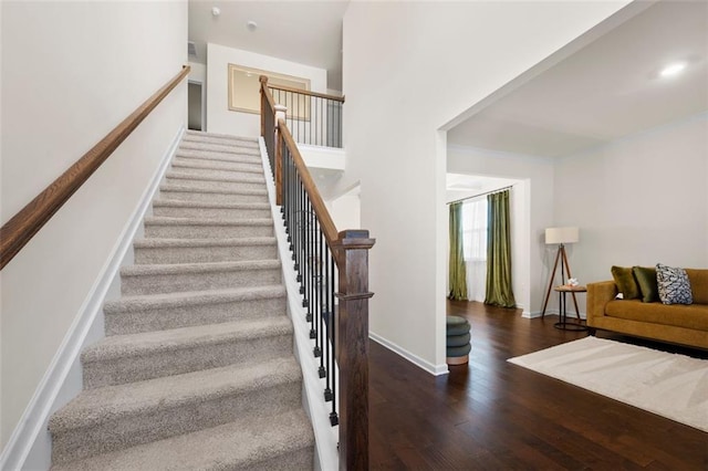 staircase featuring baseboards and wood finished floors