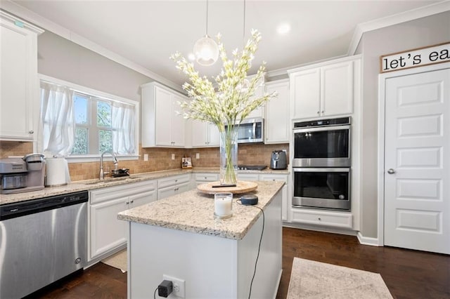 kitchen with crown molding, appliances with stainless steel finishes, decorative backsplash, and a sink