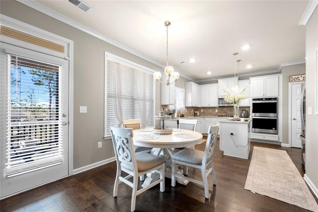 dining space with ornamental molding, dark wood finished floors, visible vents, and an inviting chandelier