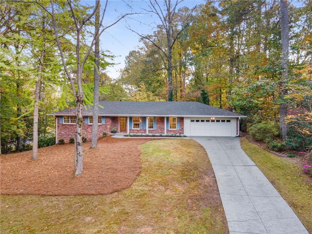 ranch-style house featuring a front lawn and a garage