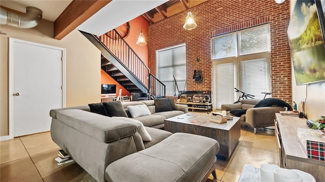 living room featuring a high ceiling, light tile patterned flooring, brick wall, and beam ceiling