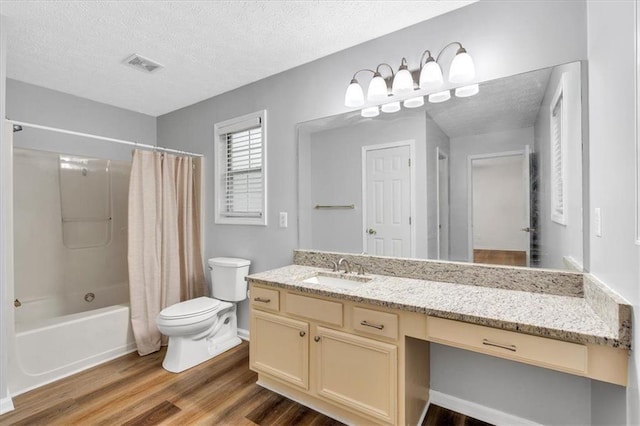 bathroom featuring vanity, toilet, a textured ceiling, wood finished floors, and visible vents
