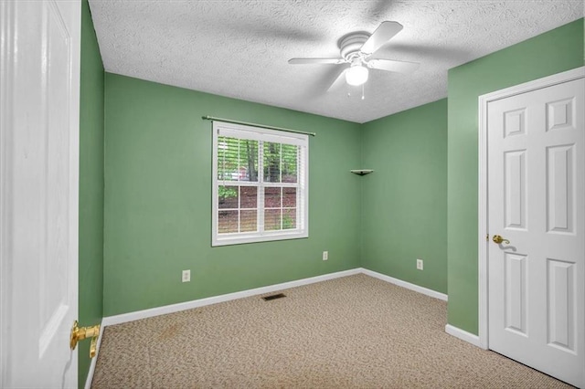 unfurnished bedroom with carpet floors, visible vents, baseboards, a textured ceiling, and a ceiling fan