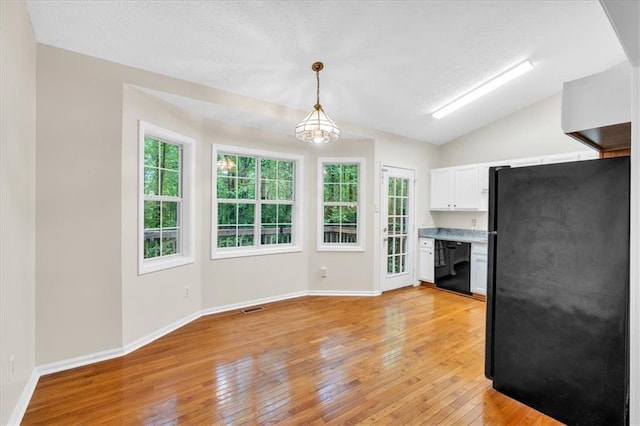 unfurnished living room featuring baseboards, light wood-style flooring, lofted ceiling, and a healthy amount of sunlight