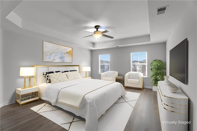 bedroom featuring a tray ceiling, ceiling fan, and dark hardwood / wood-style floors