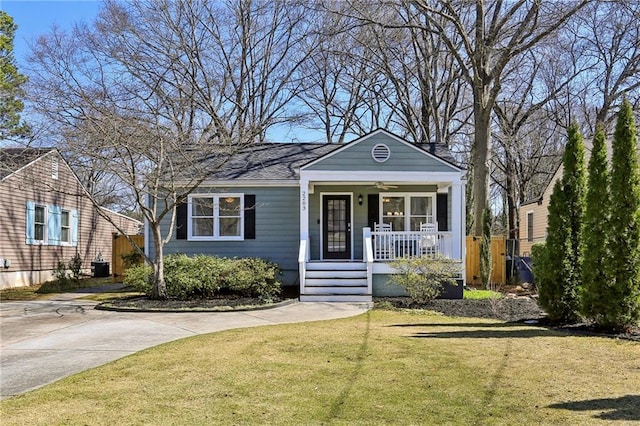 view of front of home featuring a porch, a front lawn, and central AC