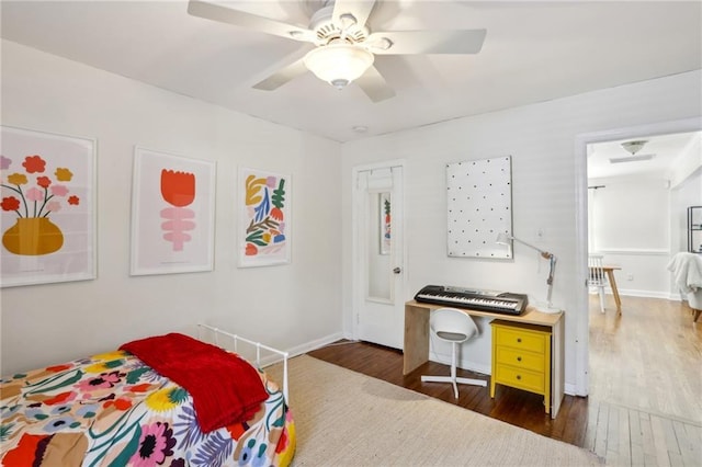 bedroom with a ceiling fan, wood finished floors, and baseboards