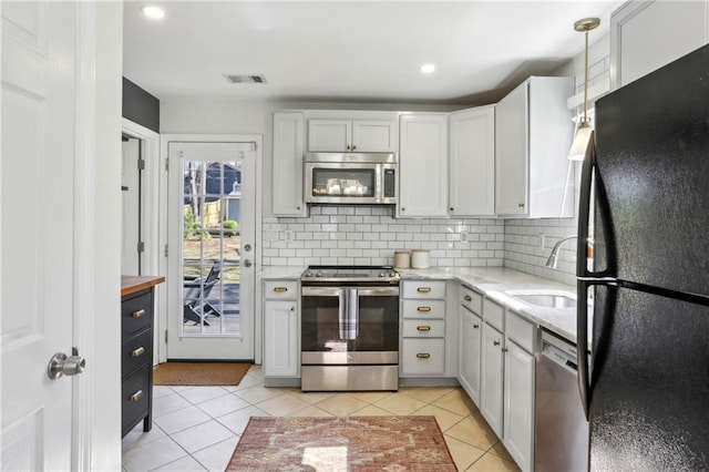 kitchen featuring backsplash, light tile patterned flooring, visible vents, and appliances with stainless steel finishes