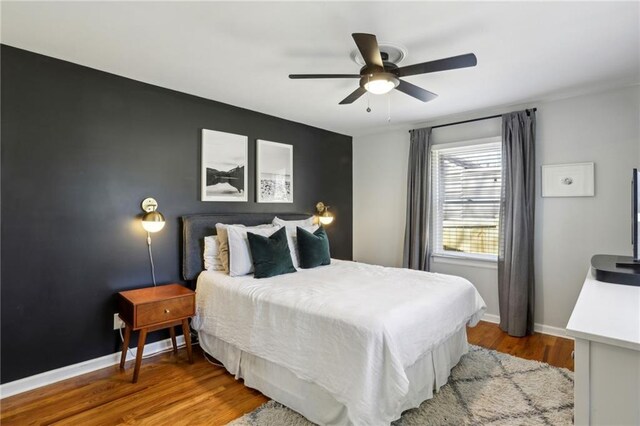 bedroom featuring wood finished floors, baseboards, and ceiling fan