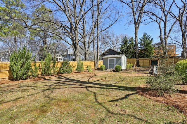 view of yard featuring a fenced backyard, an outdoor structure, and a shed