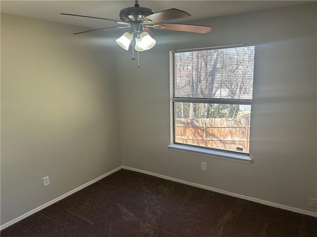 empty room with dark carpet, baseboards, and ceiling fan