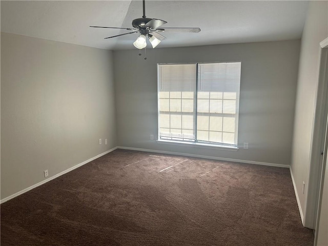 carpeted spare room with a ceiling fan and baseboards