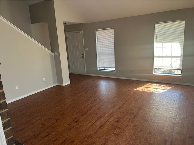 unfurnished living room with dark wood-style floors and baseboards