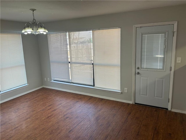 interior space with baseboards, wood finished floors, and a chandelier