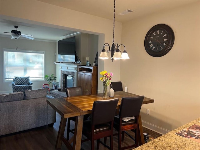 dining room with visible vents, baseboards, dark wood-style floors, ceiling fan, and a fireplace